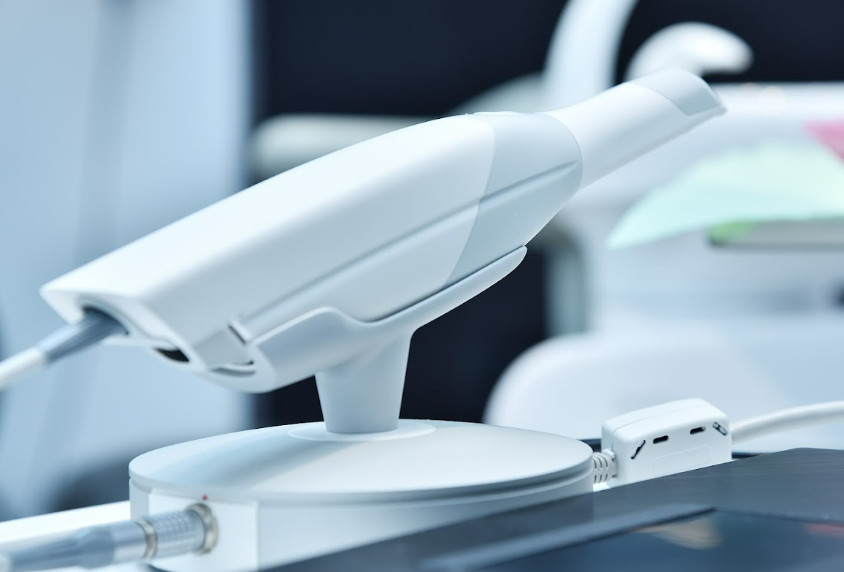 High-resolution intraoral scanner wand docked on its stand in a dental office.